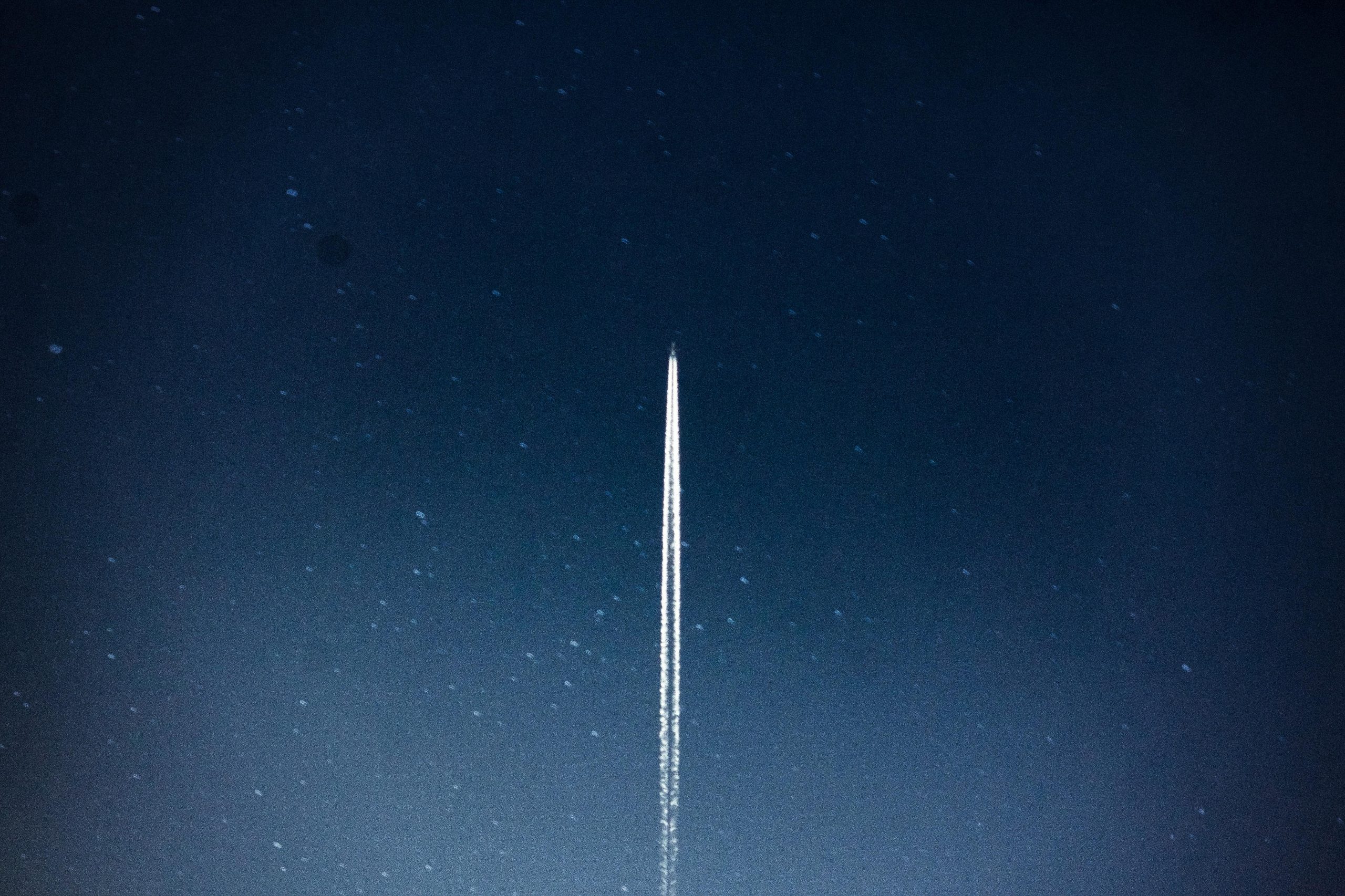 A rocket streaks through a starry night, leaving a trail in outer space.